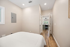 A bedroom with a bed, a wardrobe, and a door leading to a bathroom.
