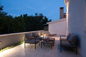 A rooftop patio with outdoor furniture, a fire pit, and a view of trees and a building. - Villa White Rose with heated pool in Kaštela (Kaštel Lukšić)