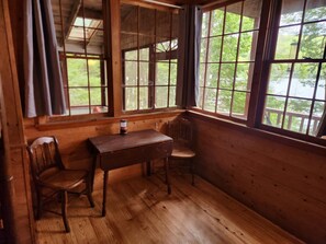 Une pièce en bois, avec un bureau, deux chaises et de grandes fenêtres.