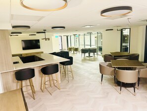 A modern interior with a bar area, seating, and a flat-screen TV. - Waterfront luxurious 2-bedroom/2 bath apartment in fabulous Kelowna (Kelowna)