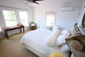 A bedroom with a large bed, a desk, and a chair. There are windows and a ceiling fan. - Cozy Cabin Lake Burton (Tiger)