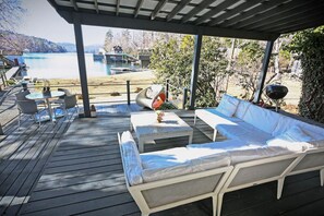 A covered outdoor deck with a pool, lounge chairs, and a table. - Cozy Cabin Lake Burton (Tiger)