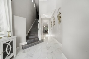 Ein modernes Interieur mit Treppe, Marmorböden und Wandkunst.