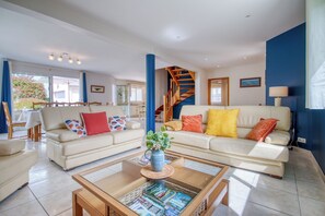 A spacious living area with two sofas, a coffee table, and a staircase. - Les Azurs d'Erdeven - Terrasse - Jardin (Erdeven)