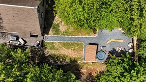 Luchtbeeld van een dak met een terras, een waterpartij en omliggend groen.