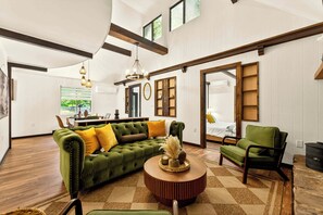 A spacious living room with a green sofa, a round coffee table, and a dining area in the background. - Long Pond Retreat w/ Hot Tub, Sauna & Fire Pit (Long Pond)