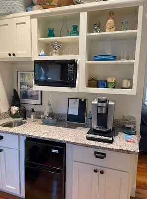 A kitchen with white cabinets, a microwave, a coffee maker, and a sink. - Suite B  1 King bed and 1 sofa bed (Winona Lake)