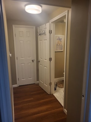 A hallway with wooden flooring, white doors, and a ceiling light fixture. - Cozy 1-bedroom apartment in lovely Saint Georges with AC (Saint Georges)