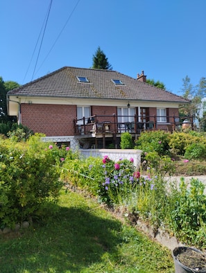 A two-story house with a brick facade, a tiled roof, and a small balcony with a wooden railing. - Maple Tree Cottage (Aubermesnil-aux-Érables)
