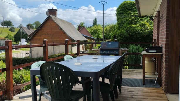 Un patio exterior con una mesa y sillas, una parrilla y un calentador de agua.