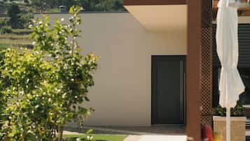 Ein modernes Gebäude mit flachem Dach, einer Tür und einem kleinen Garten mit einem Weg.