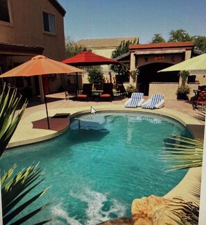Une piscine avec des chaises longues et des parasols.