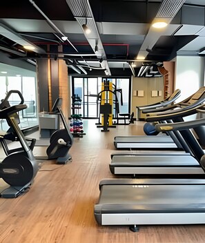 Uma academia com esteiras, bicicleta ergométrica e aparelhos de musculação.