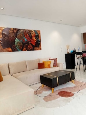 Ein modernes Wohnzimmer mit einer Couch, einem Couchtisch und einem großen, abstrakten Gemälde an der Wand.