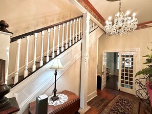 A grand staircase with white balusters, a chandelier, and a table with a lamp. - Spacious 6-bedroom house in tranquil Tracy City with AC (Tracy City)