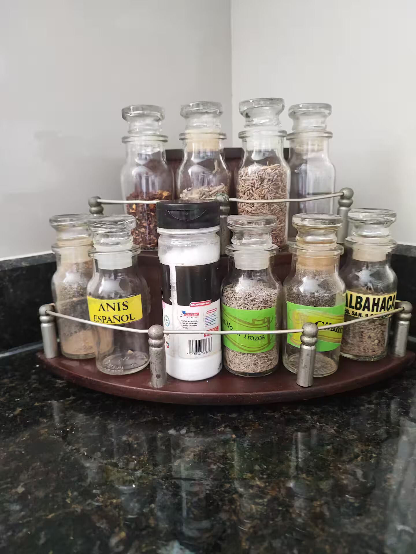 Um porta-temperos com vários frascos de vidro contendo diferentes especiarias.