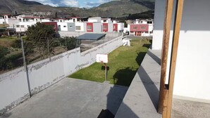 A residential area with houses, a basketball court, and a view of distant mountains.