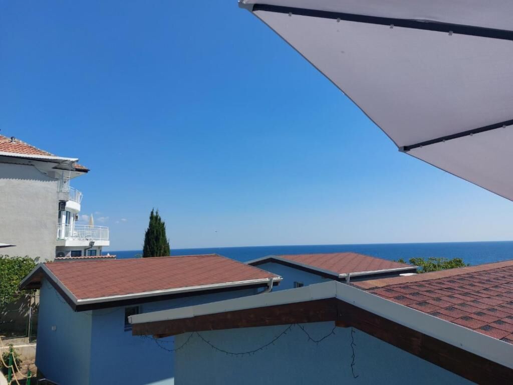 Ein Gebäude mit rotem Ziegeldach, weißer Außenwand und freiem Blick auf den Ozean.