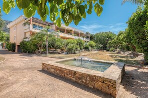 A building with a pool, surrounded by trees and a clear sky. - Luxury 3-bedroom apartment, 350 m from Saint-Clair beach (Le Lavandou)