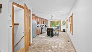 Una cocina moderna con armarios de madera, una isla central y taburetes de bar.