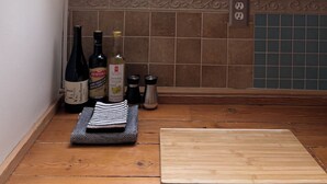 Eine Küche mit Oberlicht, einem Holzschnittbrett, einer Weinflasche und einer Pflanze.