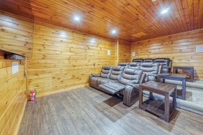 Ein Zimmer mit Holzwänden, einer ledernen Liegesofa, einem kleinen Tisch und einem Feuerlöscher.