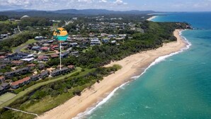 An aerial view of a coastal residential area with houses, a beach, and a clear sky. - Salt on Sapphire - steps away from Campbells Beach (Sapphire Beach)
