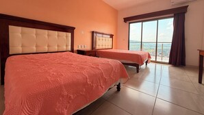 A hotel room with two beds, a large window, and a balcony.