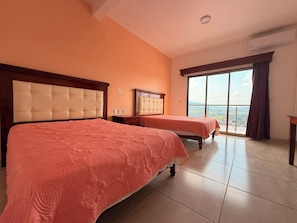 A hotel room with two beds, a large window, and a balcony. - Hotel Mirador Santiago (Santiago Tuxtla)