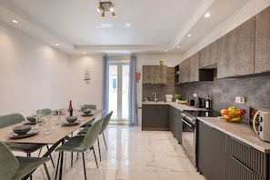 Eine moderne Küche mit Essbereich, ausgestattet mit Backofen, Spüle und einer Arbeitsfl äche mit Obstschale.