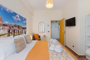 A hotel room with a bed, a painting of a bridge, a television, and a door labeled 'Borgo'. - Apartment 'Il Sogno in Rome -' with Balcony, Wi-Fi and Air Conditioning (Rome)