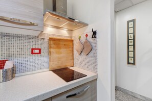A kitchen with a wooden countertop, a built-in oven, and a backsplash with square tiles. - Apartment 'Il Sogno in Rome -' with Balcony, Wi-Fi and Air Conditioning (Rome)