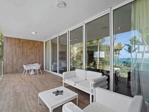 Una sala de estar moderna con un sofá blanco, una mesa de centro y un comedor con sillas blancas.