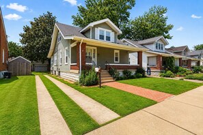 A single-story house with a front porch, a garage, and a well-maintained lawn. - Grand Louisville estate near Historic Churchill! (Louisville)
