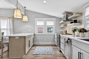 A modern kitchen with a central island, pendant lighting, and a view to the outside. - Grand Louisville estate near Historic Churchill! (Louisville)