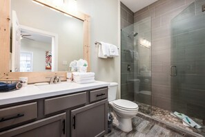 Un baño moderno con ducha, inodoro y tocador.