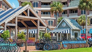 Um hotel com estação de aluguel de bicicletas, área coberta e um edifício com varanda.