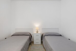 A twin room with two beds, a nightstand, and a lamp. - NG Zenith - Santa Cruz de Tenerife (Santa Cruz de Tenerife)