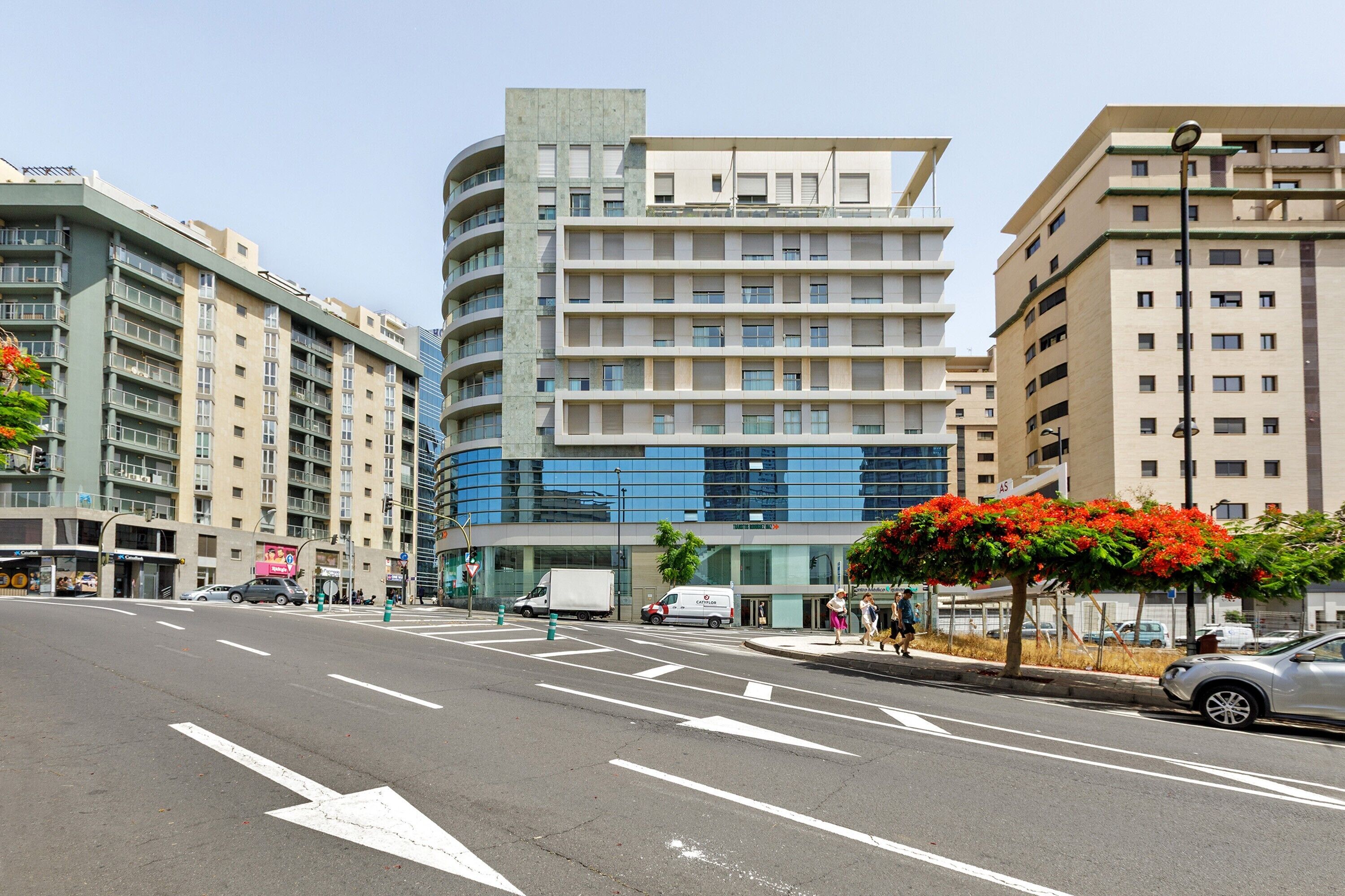 A multi-story building with a modern architectural design, featuring a mix of glass and concrete facades.