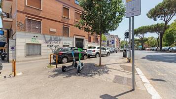 Una strada con una fermata dell'autobus, auto parcheggiate e un edificio con graffiti.