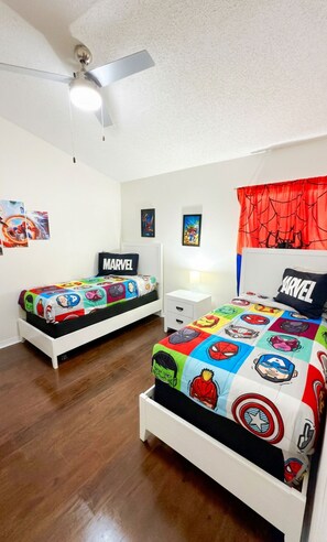 Ein Schlafzimmer mit zwei Betten, jedes mit einer Bettdecke im Marvel-Design.