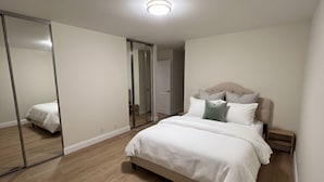 Una camera da letto con un letto, uno specchio, un armadio e una porta.