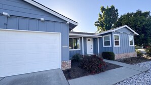 Una casa residenziale con garage, veranda e un piccolo giardino.