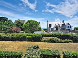 A house with a large garden, a swimming pool, and a view of the sea.