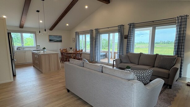A spacious living area with a sofa, dining table, and kitchen in the background.