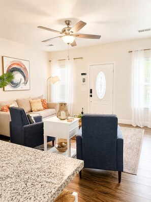 A living room with a ceiling fan, a sofa, a coffee table, and a chair. - Pass Time Retreat- 1/2 Mile to the beautiful Pass Christian Beaches- Sleeps 6 (Pass Christian)