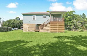 A two-story house with a wooden deck and a covered porch. - Pass Time Retreat- 1/2 Mile to the beautiful Pass Christian Beaches- Sleeps 6 (Pass Christian)