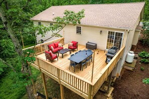 Eine Terrasse mit Gartenmöbeln, Grill und Warmwasserbereiter.