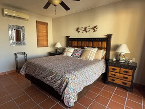 A bedroom with a bed, nightstands, a ceiling fan, a mirror, and a wall decoration. - AV220 Villa in Loreto Bay. Short walk to Beach, Pools, Restaurants,4 Bikes & AC. (Nopolo)