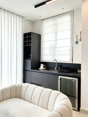 Eine moderne Küche mit Einbauofen, Spüle und einem Fenster mit Jalousien.